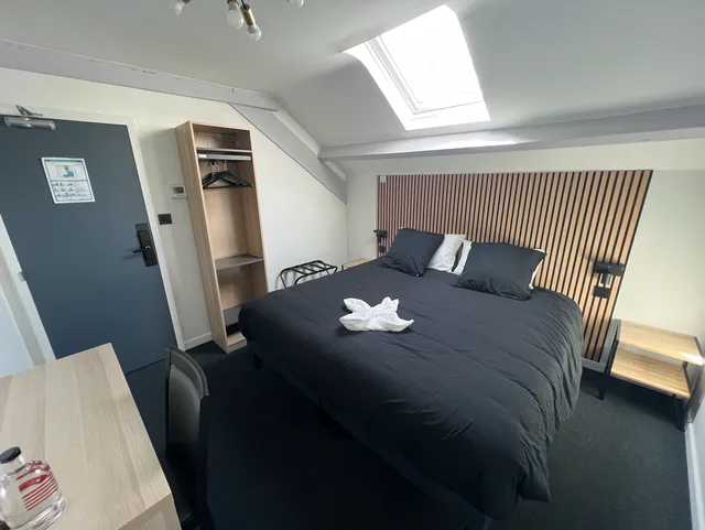 Chambre King Supérieure sous combles avec verrière Velux apportant une lumière naturelle au-dessus du lit